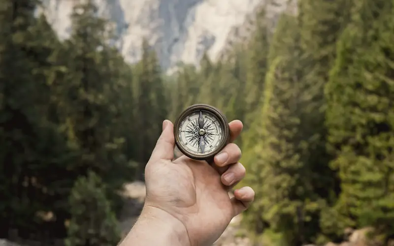 Kompas in een hand in het bos