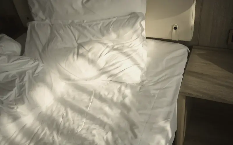 Bed met zonlicht op de lakens