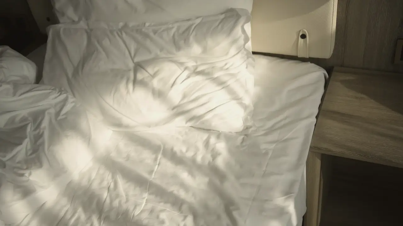 Bed met zonlicht op de lakens