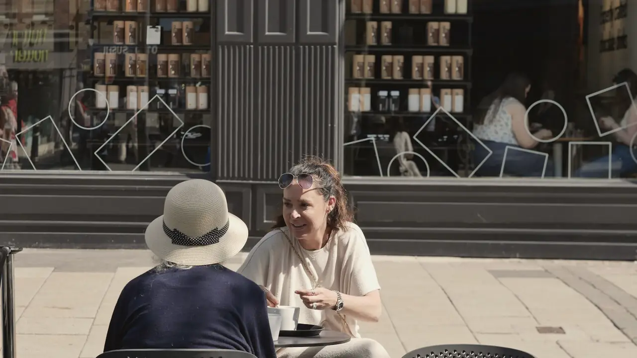 Twee vriendinnen in gesprek op een terras