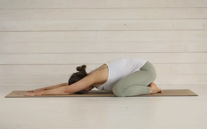 Vrouw in een rustige rekhouding op een yogamat