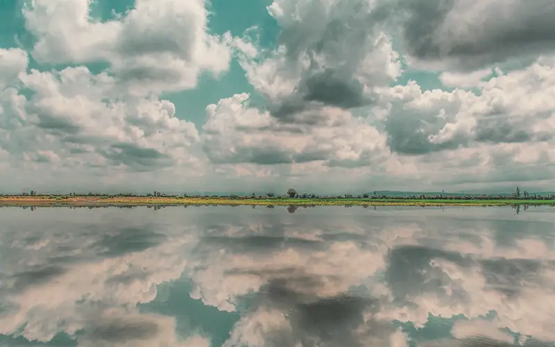 Wolken die weerspiegelen in stil water