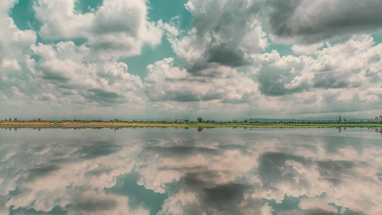 Wolken die weerspiegelen in stil water