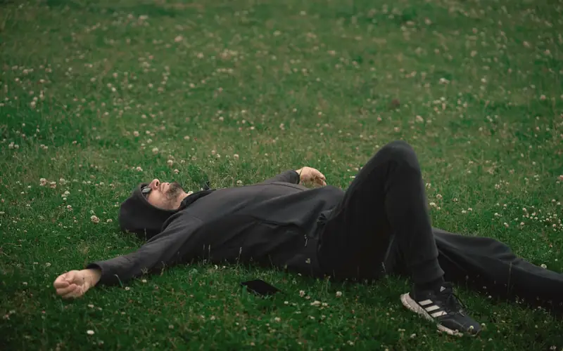 Man die ontspannen in het gras ligt