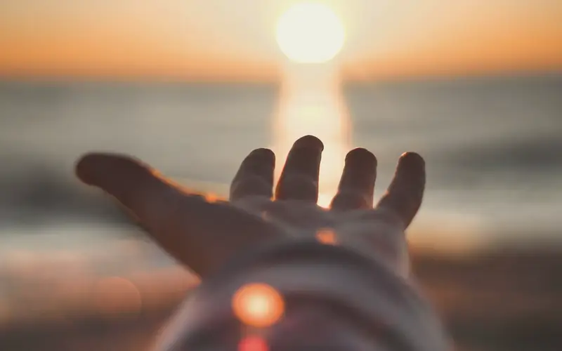 Hand die naar het licht reikt