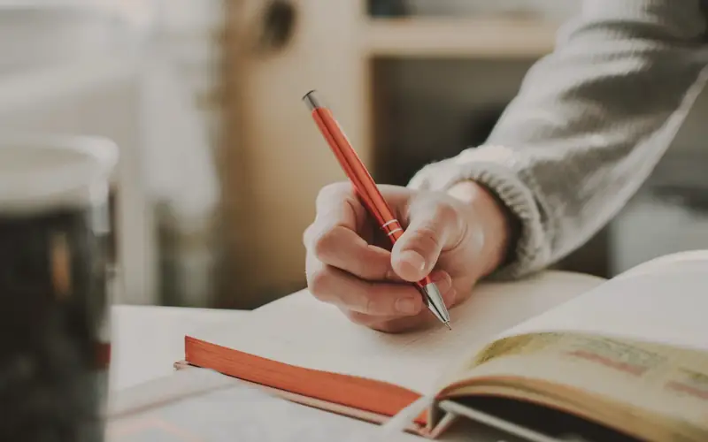 Hand die schrijft in een notitieboek
