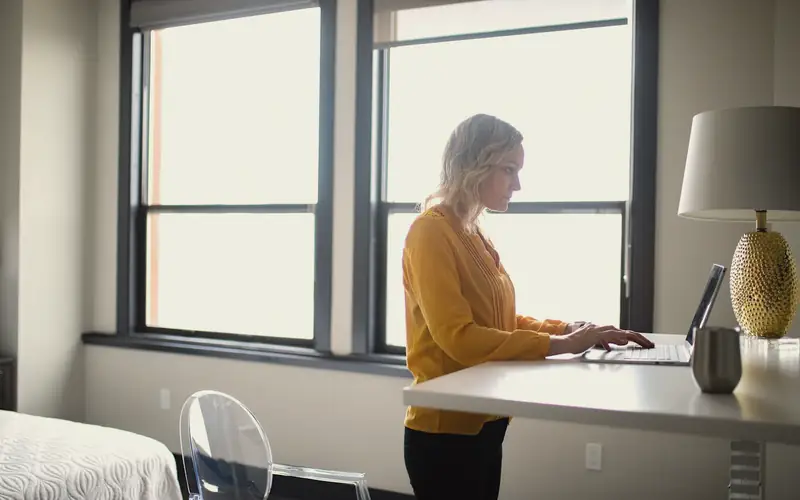Vrouw aan een bureau bij het raam